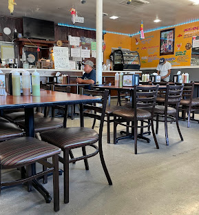 The bright dining room at Los Tacos Paco with wooden tables and chairs